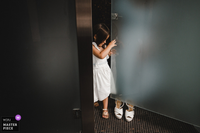 Viana do Castelo - Portugal tiempo de preparación para el matrimonio imagen premiada que captura a una niña de las flores con una puerta de cristal. Los mejores concursos de imágenes de bodas del mundo los organiza la WPJA