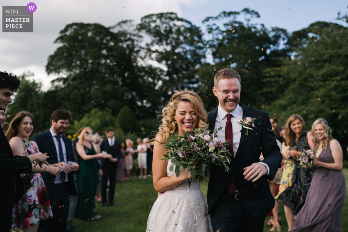 Eggington House, Reino Unido, ceremonia de matrimonio al aire libre, imagen premiada que muestra un momento de confeti al aire libre. Los mejores concursos de fotografía de bodas del mundo presentados por la WPJA