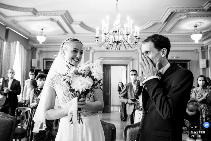 Imagen premiada de la ceremonia de matrimonio en interiores de Lyon que muestra al novio conmovido al ver a su esposa. Los mejores concursos de fotografías de bodas del mundo se presentan a través de la WPJA