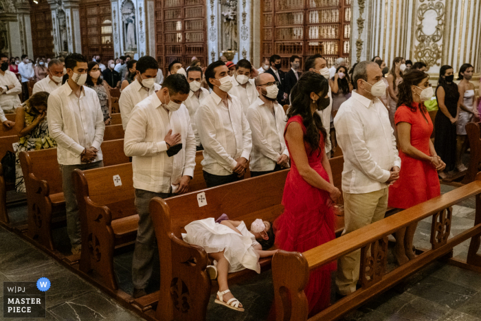 Chiesa di Santo Domingo, immagine premiata della cerimonia di matrimonio al coperto della città di Oaxaca che mostra una fioraia addormentata durante la cerimonia. I migliori concorsi di foto di matrimonio al mondo sono presentati tramite il WPJA