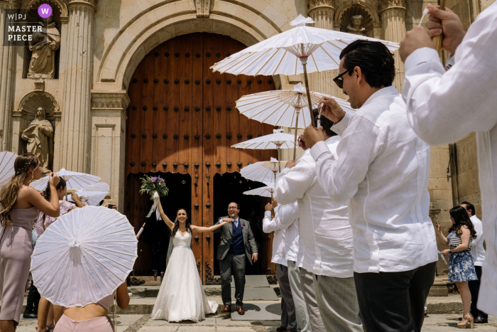 Église de Santo Domingo, image primée du mariage de la ville d'Oaxaca montrant la sortie de la cérémonie des couples. Les meilleurs concours de photos de mariage au monde présentés par la WPJA