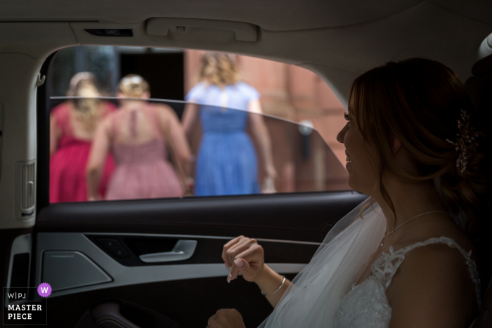 Imagen premiada del día nupcial de Estrasburgo de la novia en un coche frente al ayuntamiento. Los mejores concursos de fotografía de bodas del mundo son organizados por la WPJA