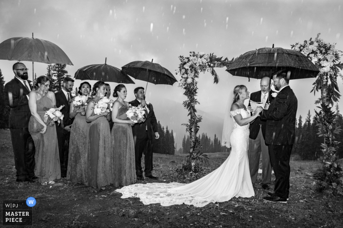 Timber Ridge Lodge, imagem premiada da cerimônia de casamento ao ar livre em Keystone mostrando A cerimônia sendo inundada por fortes chuvas, causando seu encurtamento