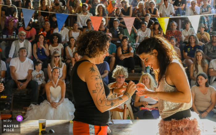 Calvaire du Mont Arès - Chemin du Mont outdoor marriage ceremony award-winning image showing The couple exchanging rings during the ceremony Calvaire du Mont Arès - Chemin du Mont outdoor marriage ceremony award-winning image showing The couple exchanging rings during the ceremony.