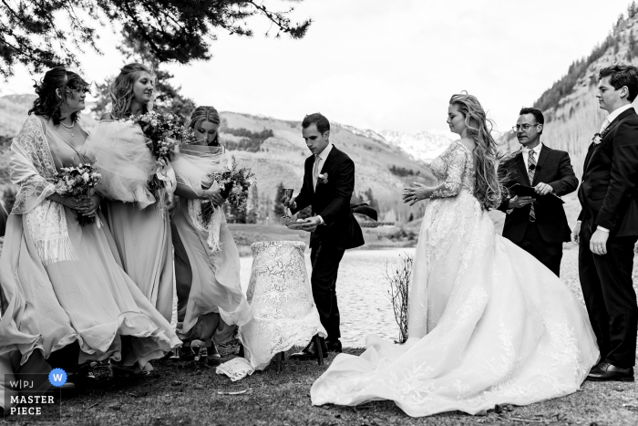 Imagen premiada de la ceremonia de matrimonio de Colorado que muestra momentos de viento al aire libre en BW, de los mejores concursos de fotografía de bodas del mundo presentados por la WPJA