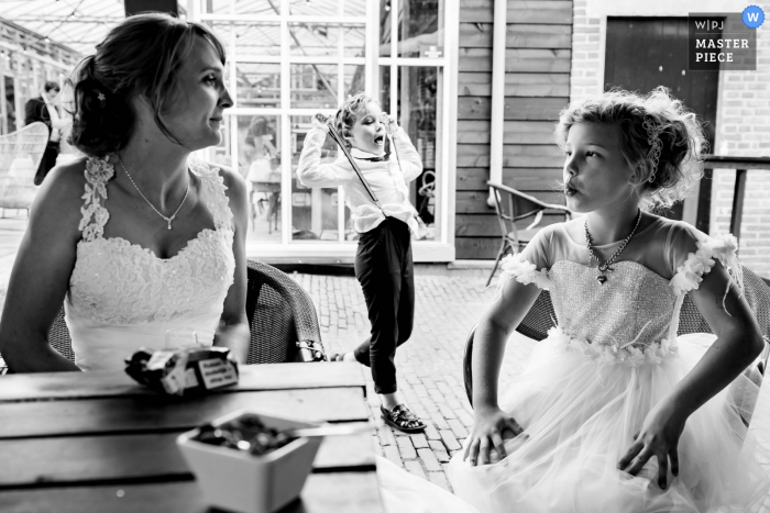 Noord Brabant marriage reception party award-winning photo that has recorded kids and the bride in black and white - from the world's best wedding photography competitions offered by the WPJA