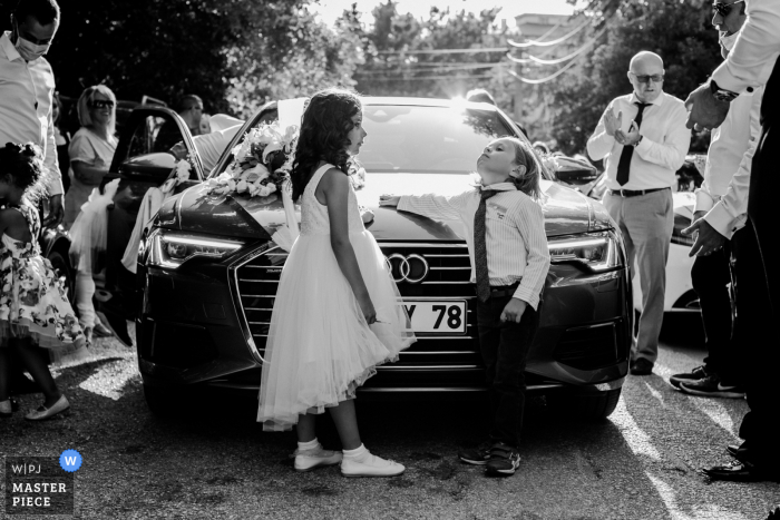 Imagem vencedora do prêmio do dia nupcial de Bursa dos jovens convidados apoiados em um belo carro - das melhores competições de fotografia de casamento do mundo promovidas pela WPJA