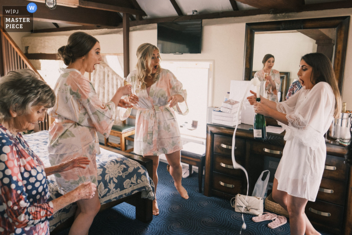 Le moulin de Ballydugan, Downpatrick se prépare pour la capture d'une photo primée du mariage La mariée a du mal à contenir le champagne jaillissant d'une bouteille fraîchement ouverte - parmi les meilleurs concours de photographie de mariage au monde organisés par la WPJA