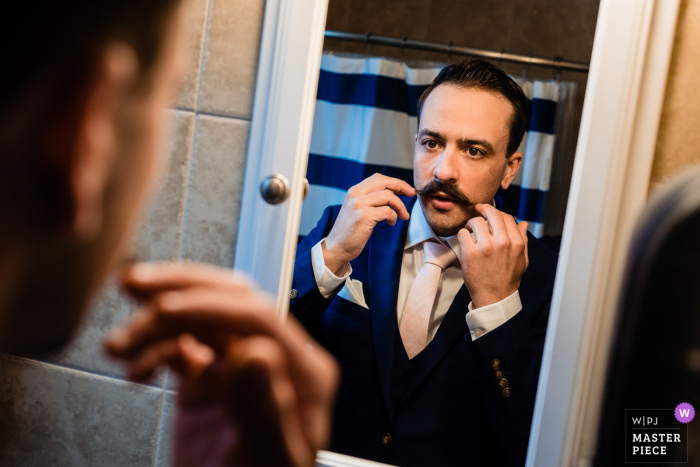 Pennsylvania getting ready for marriage award-winning picture capturing the Groom doing one final mustache check before heading off to the ceremony Pennsylvania getting ready for marriage award-winning picture capturing the Groom doing one final mustache check before heading off to the ceremony - from the world's best wedding photography competitions held by the WPJA