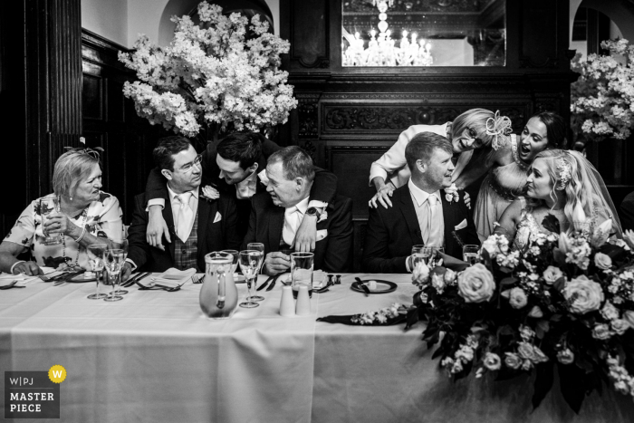 Whitley Hall, Inglaterra.Foto galardonada de la fiesta de recepción matrimonial que ha grabado.La novia y el novio y los invitados conversan y se felicitan después de unos maravillosos discursos, de los mejores concursos de fotografía de bodas del mundo ofrecidos por la WPJA.