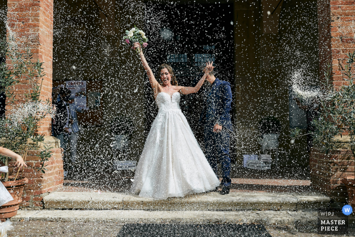 Chiesa di San Lucchese - Imagem premiada da cerimônia de casamento Poggibonsi mostrando A saída explosiva da noiva - dos melhores concursos de fotografia de casamento do mundo apresentados pela WPJA