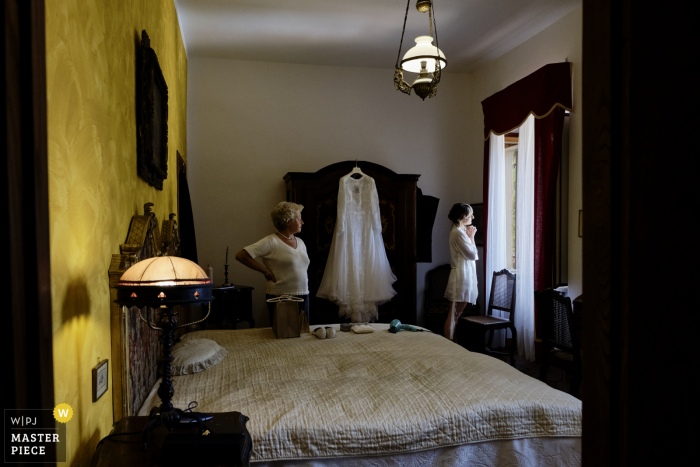 Abbazia Santo Spirito, Comignago bereitet sich auf die Hochzeit vor preisgekröntes Bild, das die Braut beim Blick aus dem Fenster zeigt - von den weltweit besten Hochzeitsfotografie-Wettbewerben der WPJA