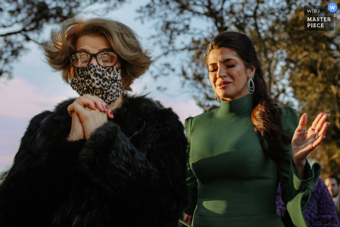 Estância das Oliveiras - Viamão marriage ceremony award-winning image showing the Sister and grandmother of the bride praying outside - from the world's best wedding photography competitions presented by the WPJA