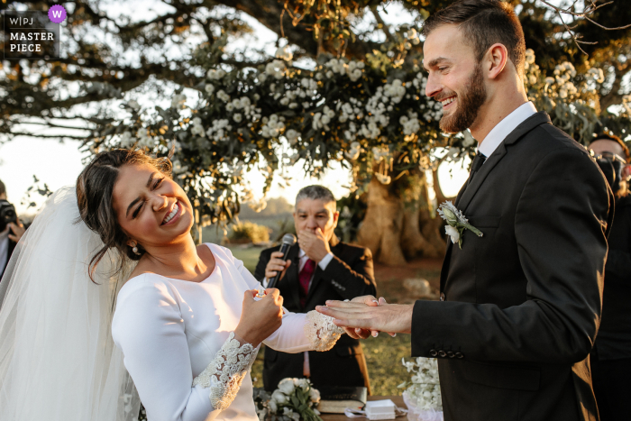 Estância das Oliveiras – Preisgekröntes Bild der Hochzeitszeremonie in Viamão, das die lachende Braut zeigt, als sie ihren Ehering vermisst – aus den weltbesten Hochzeitsfotografie-Wettbewerben der WPJA