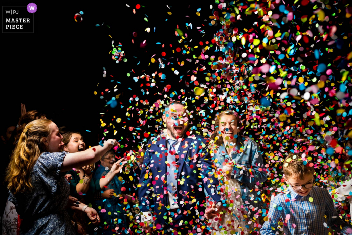 Wake Forest, NC-huwelijksceremonie bekroonde afbeelding waarop bruid en bruidegom door confetti lopen als onderdeel van hun speciale uitgang - van 's werelds beste huwelijksfotografiewedstrijden gepresenteerd door de WPJA