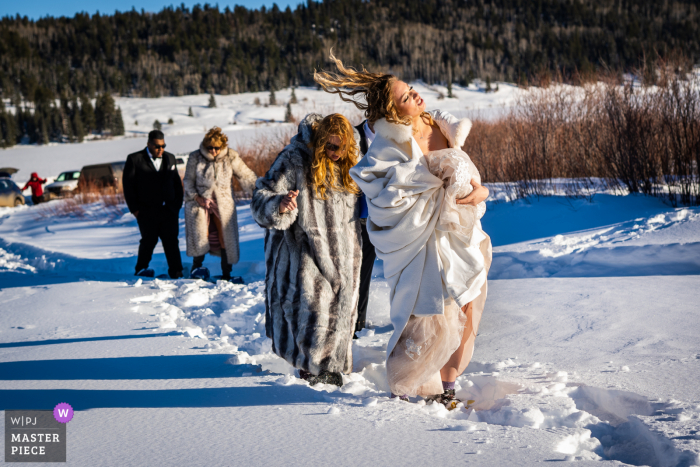 Pagosa Springs, CO, imagem vencedora do prêmio do dia nupcial de Noiva jogando o cabelo enquanto caminhava pela neve em seu caminho para sua cerimônia ao ar livre - das melhores competições de fotografia de casamento do mundo promovidas pela WPJA