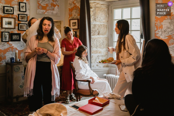 Francia preparándose en un hotel para el matrimonio galardonado con una fotografía que captura a Bride preparándose con su equipo, de los mejores concursos de fotografía de bodas del mundo organizados por la WPJA