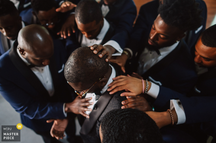 Heritage Fellowship Church, Virginia getting ready for marriage award-winning picture capturing The groom (who is also a minister) is being blessed by the groomsmen - from the world's best wedding photography competitions held by the WPJA