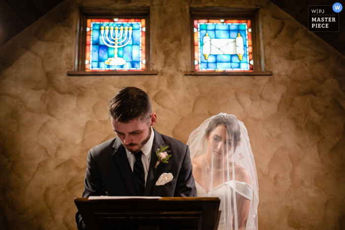 A top Montana wedding photojournalist in Grass Range created this image showing the signing of the marriage certificate