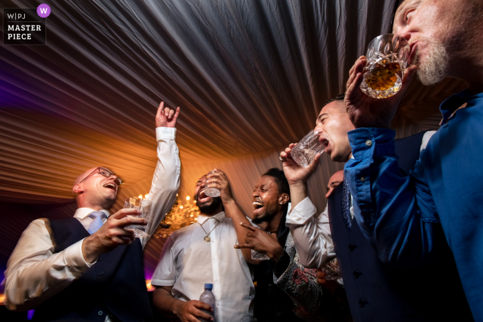 A Key West wedding photojournalist at the Ocean Key Resort captured this moment of A groom celebrating with his closest friends during a wedding reception