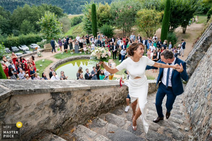 A Lyon France documentary wedding photographer captured this moment of the bride and groom Leaving the ceremony and climbing the stone steps