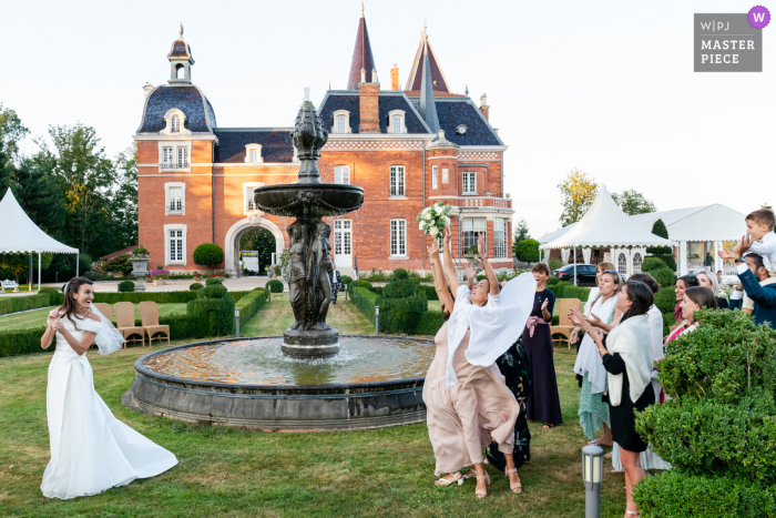 Un fotoreporter di matrimoni a Lione ha catturato questo momento della sposa che lancia il bouquet al suo ricevimento in Francia