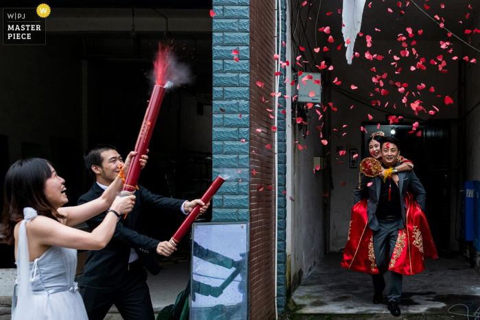 A Sichuan documentary wedding photographer captured this moment showing us When the newlyweds go out, their friends celebrate for them, The next second, fireworks are about to spray out