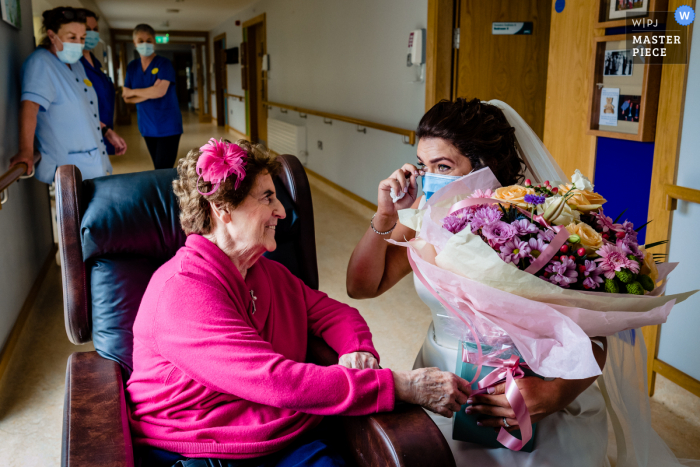 Uma imagem de casamento em estilo documentário de Offaly que mostra um momento da noiva visitando sua avó na casa de repouso depois de se casar