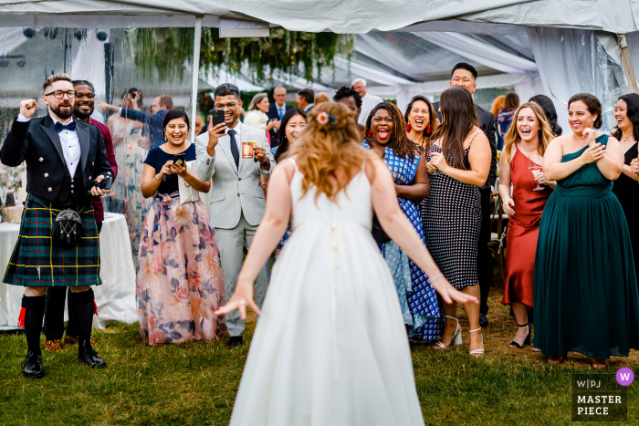 A top documentary wedding photographer from Colorado created this image during Cocktail hour as the Bride walks up to friends