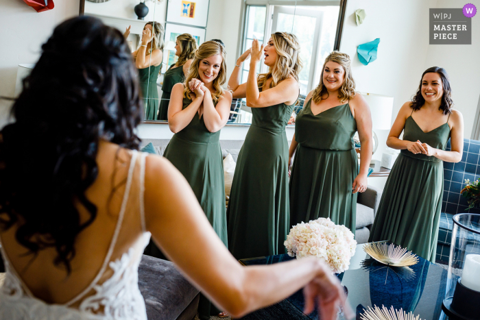 Una imagen de boda al estilo documental de Colorado que muestra un momento que muestra a las damas de honor reaccionando a la novia