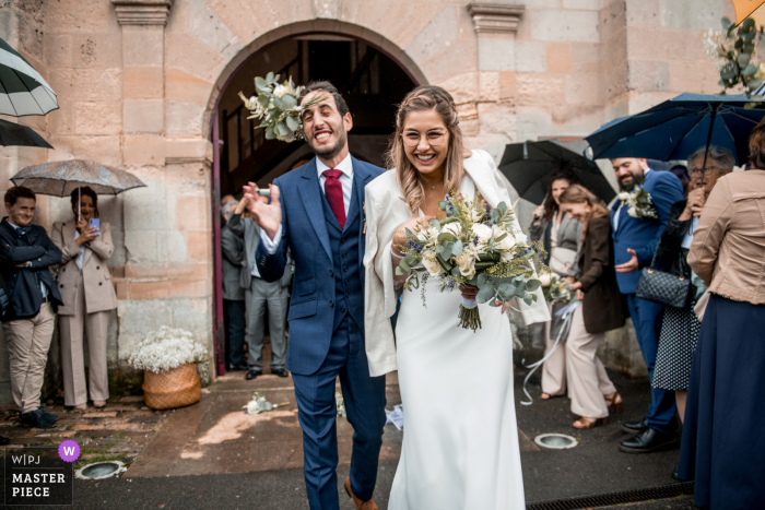 Ein führender französischer Hochzeitsreportagefotograf im Chateau de Raray hat dieses Bild einer Blume aufgenommen, die dem Bräutigam ins Gesicht geworfen wurde