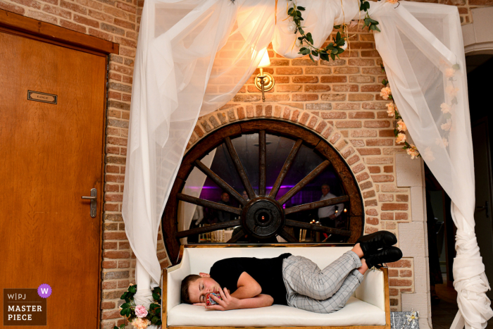 A Lille documentary wedding photographer captured this moment showing a young boy who is bored during the wedding party A Lille documentary wedding photographer captured this moment showing a young boy who is bored during the wedding party