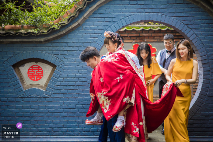 Een trouwfotojournalist in Peking legde dit moment vast van de bruid die op de rug werd gedragen