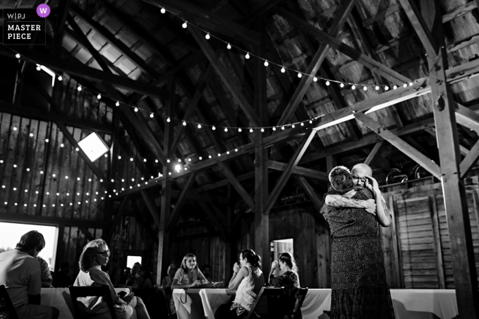 A Missouri documentary wedding photographer captured this moment in BW at the Wedding Reception of the Mom dancing with groom