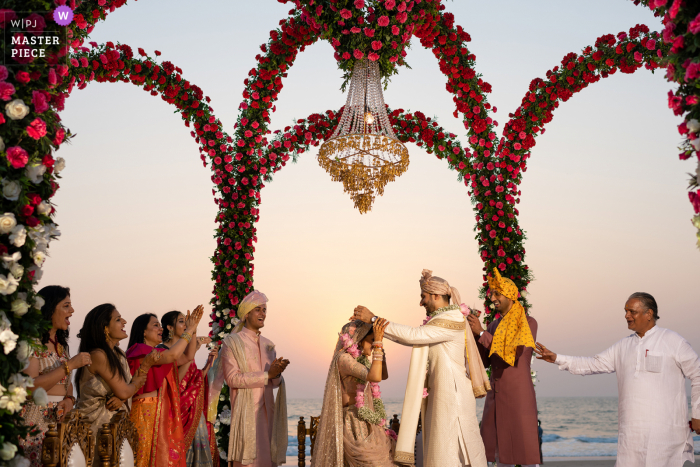 A documentary wedding photographer in Goa captured this picture showing The varied expressions during the garland exchange including that of the priest are interesting to note