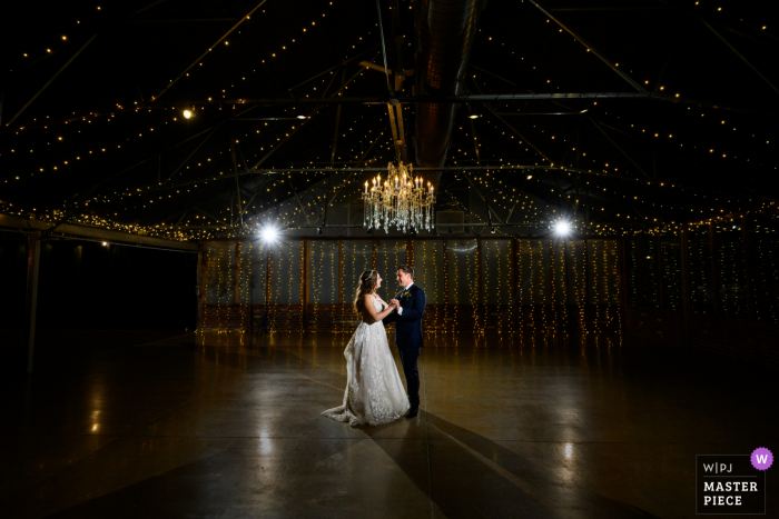 Um importante fotógrafo de documentários de casamento em Berthoud, Colorado, criou esta imagem de uma noiva e do noivo compartilhando sua primeira dança