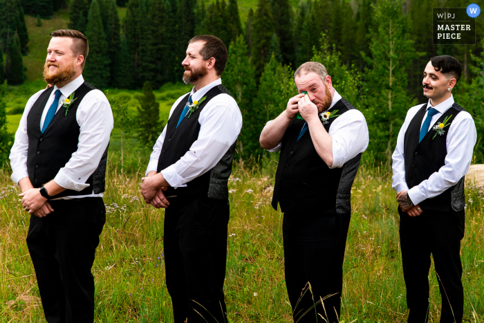 A top Vail wedding photojournalist created this image in the backcountry of a groomsman crying during ceremony A top Vail wedding photojournalist created this image in the backcountry of a groomsman crying during ceremony
