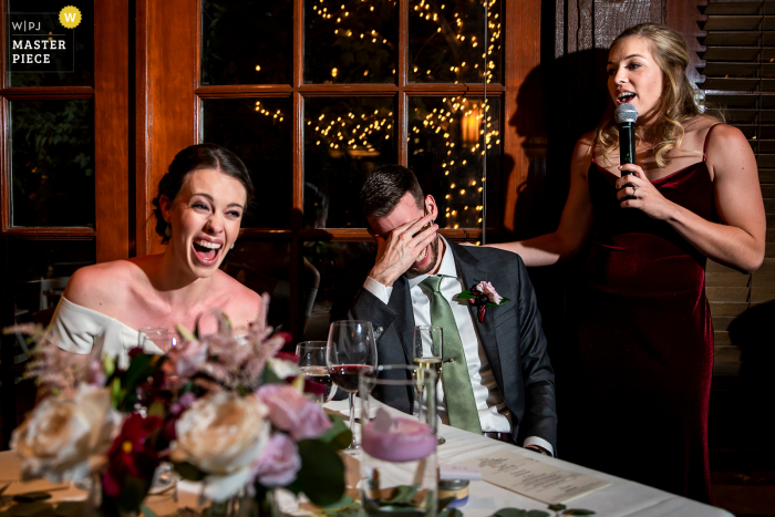 Een fotojournalist van Boulder-huwelijk bij Greenbriar Inn legde dit moment vast van de bruid en bruidegom die lachten tijdens de toespraak van het bruidsmeisje