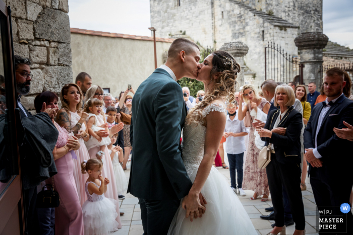 A France documentary wedding photographer at a town hall captured this picture of the kiss of the exit