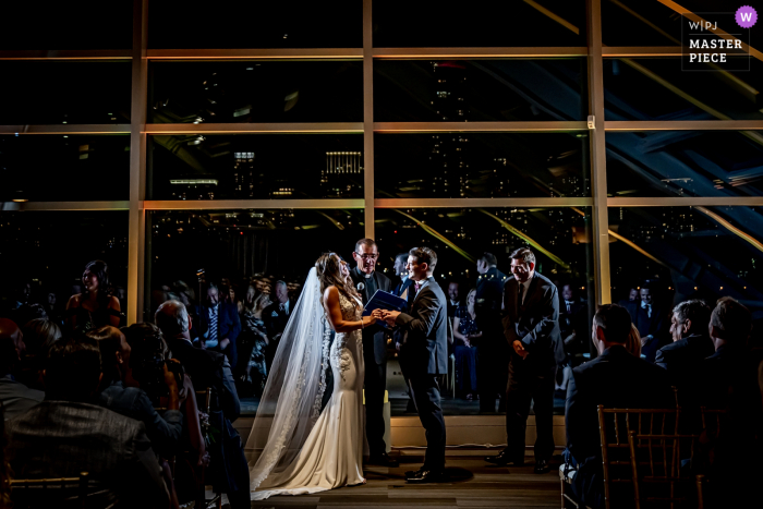 Veja esta foto do casamento em Chicago neste momento significativo no Planetário Adler durante uma cerimônia noturna