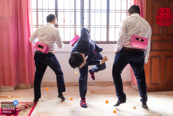 A Singapore documentary wedding photographer captured this moment of a Groom and groomsmen playing a game during gatecrashing