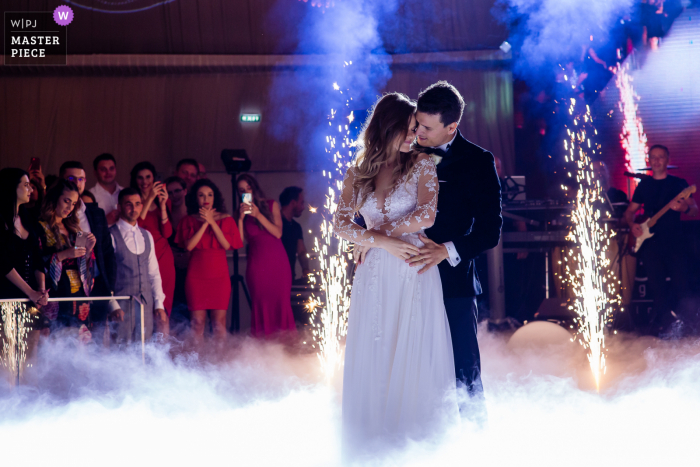A Romania documentary-style wedding image showing a moment at the Ego Ballroom Mamaia showing the first dance on the fog cloud A Romania documentary-style wedding image showing a moment at the Ego Ballroom Mamaia showing the first dance on the fog cloud