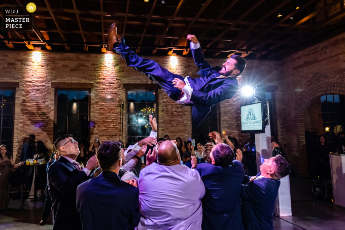 View this breathtaking Chicago wedding image at the BRIX on the Fox of a dance floor toss of the groom