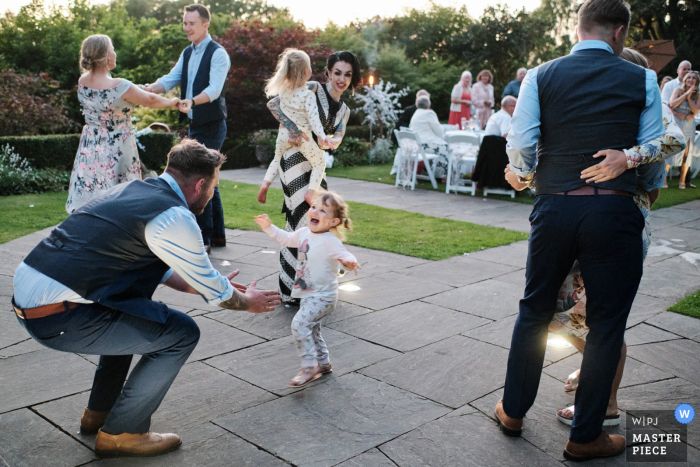 Um fotógrafo de reportagem de casamento em Staffordshire capturou este momento na The Upper House em Barlaston da filha dos noivos, vestida para dormir, correndo até ele para um abraço durante a primeira dança do casal