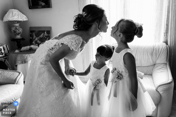 Un fotografo di matrimoni documentario a Catania ha catturato questa foto di damigelle affascinate dalla bellezza della sposa e del suo vestito