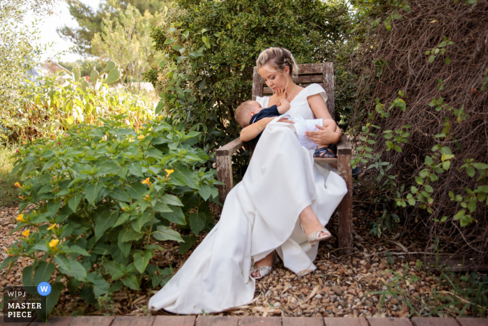 Ein dokumentarischer Hochzeitsfotograf aus Okzitanien hat diesen Moment festgehalten, in dem die Braut ihren Sohn stillt