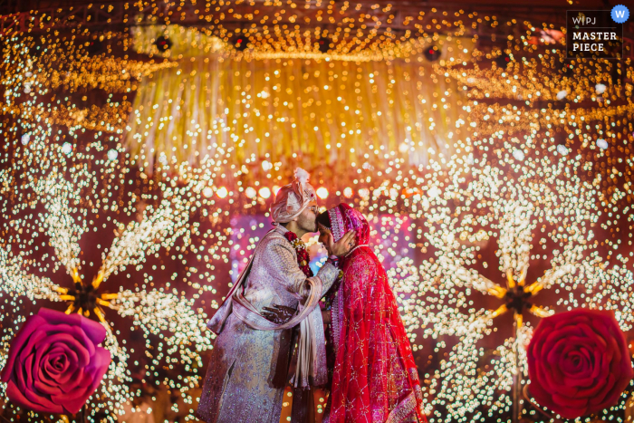 A Mumbai documentary wedding photographer captured this moment at Ajmera I-land ground of The groom kissing his bride moments after they exchange garlands as the wedding ceremonies kick off