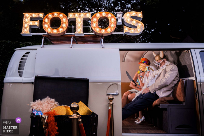 Una imagen de boda al estilo documental de Bunnik en De Landgoederij que muestra una furgoneta fotográfica es el lugar ideal para divertirse durante la recepción.