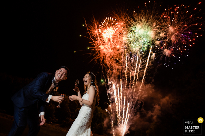 Veja esta imagem climática e sensacional de casamento na Filadélfia, o casal olhando para os convidados enquanto assistem ao show de fogos de artifício que o pai do noivo preparou para a recepção