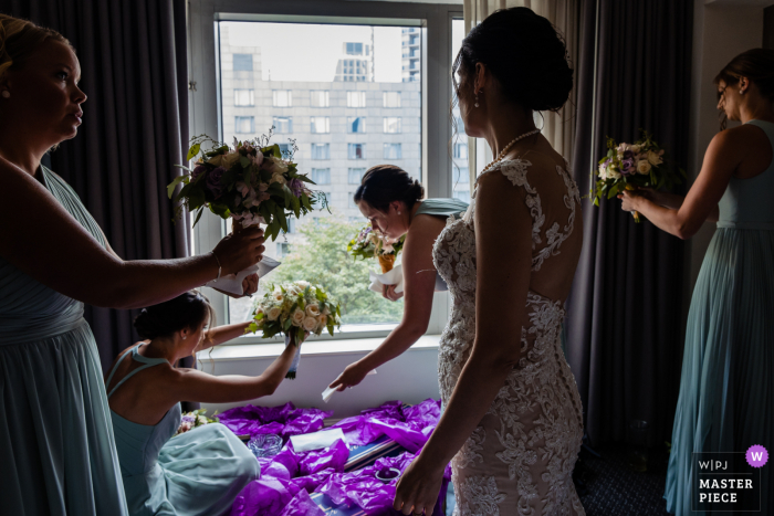 View this impressive Philadelphia wedding image showing the Bride watches as her bridesmaids team up to dry off the bouquets before heading off to the ceremony